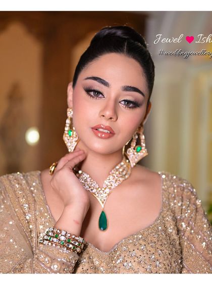 A close-up showcasing the beautiful craftsmanship of the Moissanite Polki necklace and matching earrings. The combination of uncut Polki stones and a vibrant emerald drop creates a look of timeless elegance.