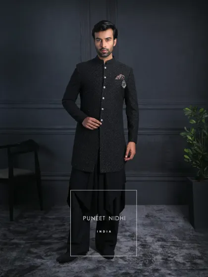 A black self-textured achkan that speaks of heritage and refinement. Paired with a draped kurta bottom and wide trousers, it carries the pride of tradition while embracing modern grace.