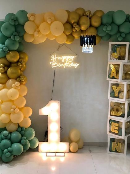 A full view of Jayden's modern first birthday setup, showing the balance of the balloon arch and the personalized name blocks.