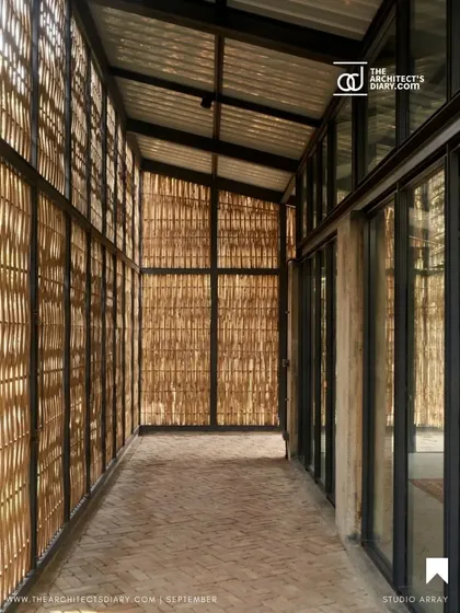 The corridor of the Artist Residency is wrapped in woven bamboo screens, creating a transitional space where the play of light and shadow is constantly changing, connecting the interior rooms to the outdoors.