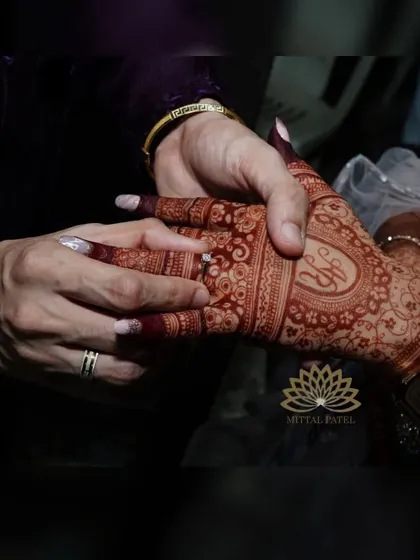 The perfect engagement stain. This photo captures the moment the ring is placed, highlighting the rich, dark color of the mehndi.