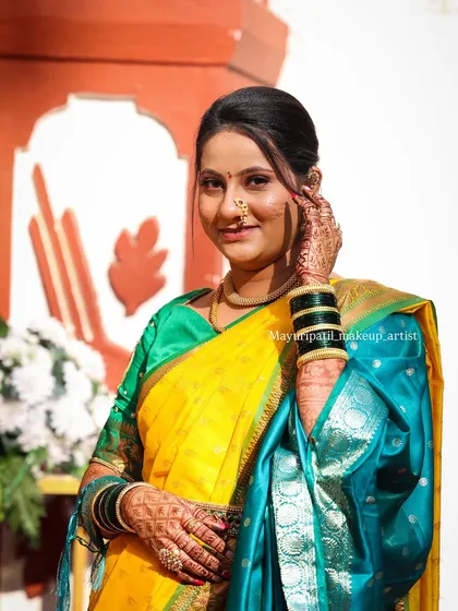 A smiling portrait of the bride. Her makeup is fresh and dewy, giving her a youthful and radiant appearance.