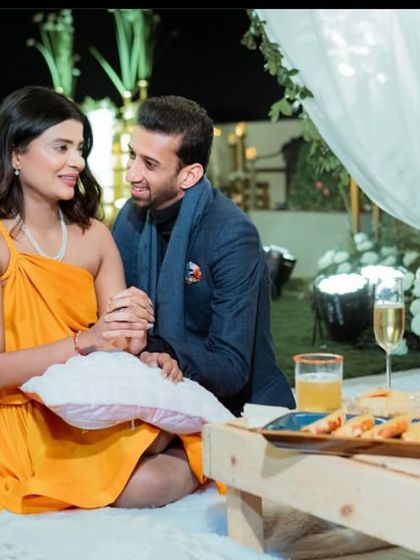 A cozy and intimate moment for two. This outdoor picnic setup for a proposal includes low seating, comfortable pillows, and a curated platter, perfect for a personal and heartfelt celebration.