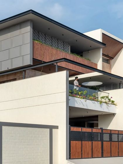 The home's design uses a series of stacked volumes and projecting balconies to create a dynamic and modern form.