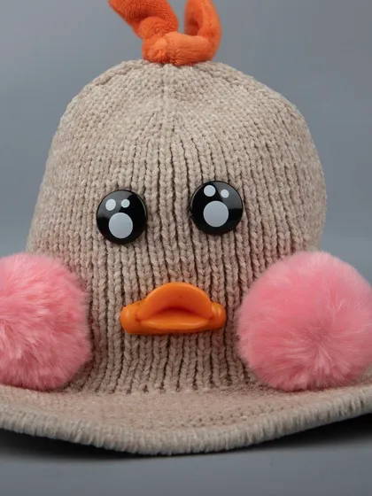 A close-up of the cute duck face on the knitted winter hat.