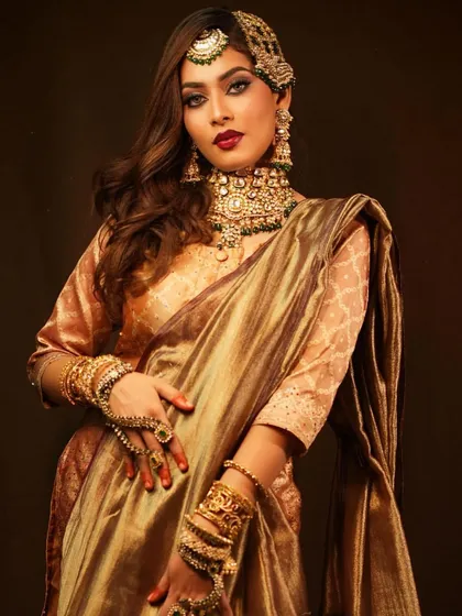 A full portrait showcasing the regal elegance of the golden-hued outfit and the perfectly complementary makeup.