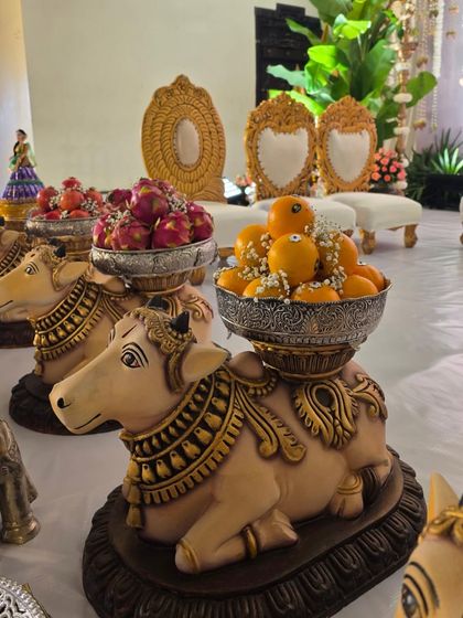 A close-up of my popular cow statues used as decorative stands for holding bowls of fruit offerings.