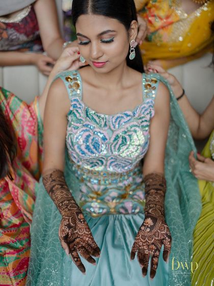 A quiet moment as the bride gets ready, her intricate mermaid-themed mehndi complete.