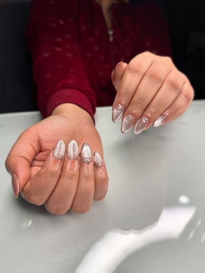 A stunning cat-eye nail extension using our no-glue technique. The silver magnetic polish creates a beautiful shimmer over the neutral base.