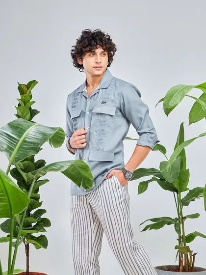 Dapper days and summer nights. This grey utility shirt paired with striped linen trousers is one of summer's finest threads, perfect for any casual occasion.
