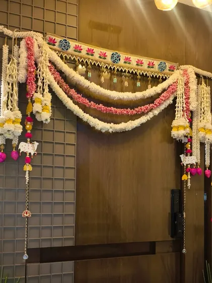 A beautiful handmade toran with artificial flowers and cow motifs, used to decorate a door for Diwali.