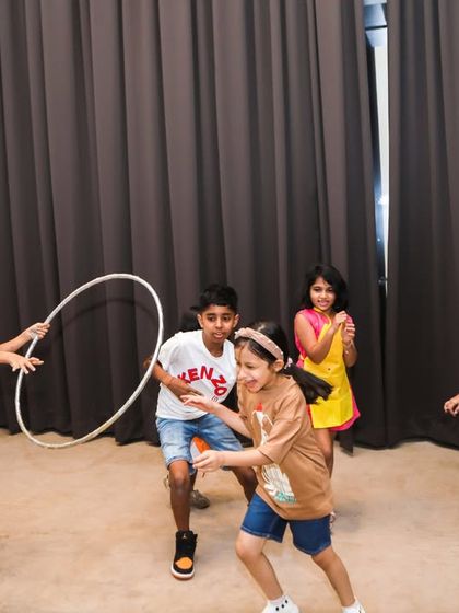 Kids engaged in a hula hoop game, showing one of the simple, classic, and fun hosted games we organize to keep the energy up.