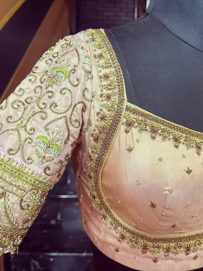 The finished blouse on a mannequin, showcasing the elegant neckline and the intricate embroidery that flows down the sleeves. This piece is ready to be paired with a beautiful Kanjivaram saree.