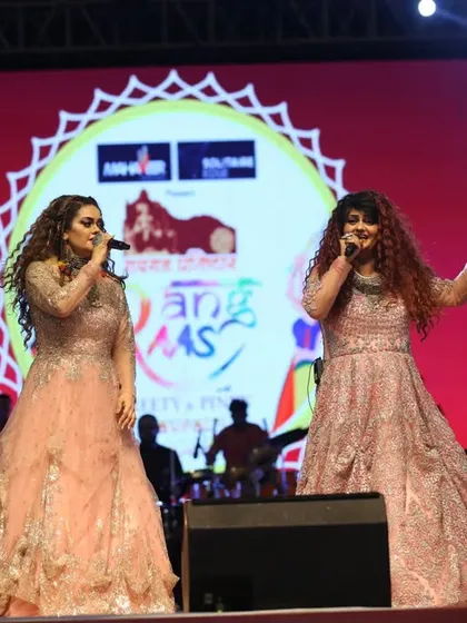 A wide shot of us on stage with a large screen displaying our event branding. We ensure a professional and polished production for every show.