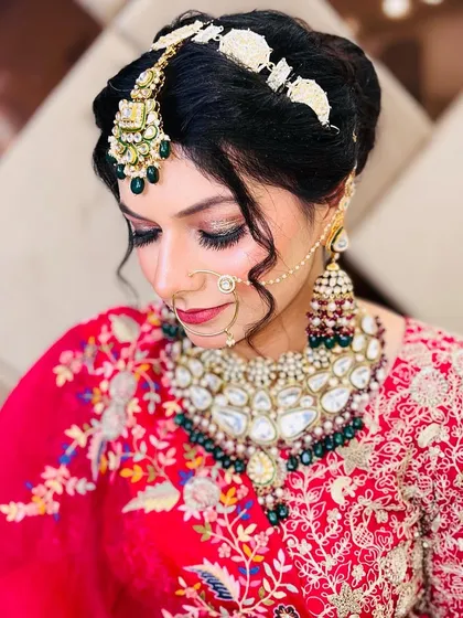 This bridal look combines elegant hair, intricate jewelry, and a flawless makeup application. The long, curled lashes are key to achieving this polished and sophisticated style.
