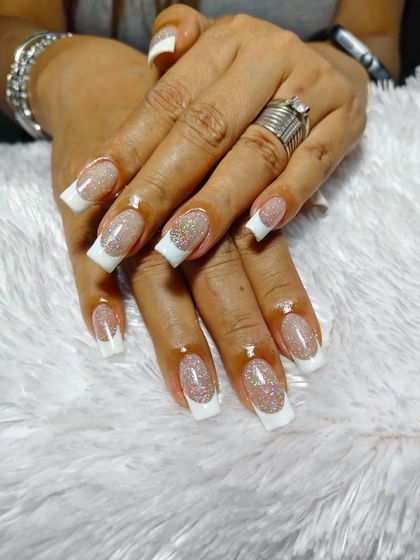 A classic French manicure with a touch of sparkle. These square-shaped extensions have a glittery nude base that beautifully complements the clean white tips.