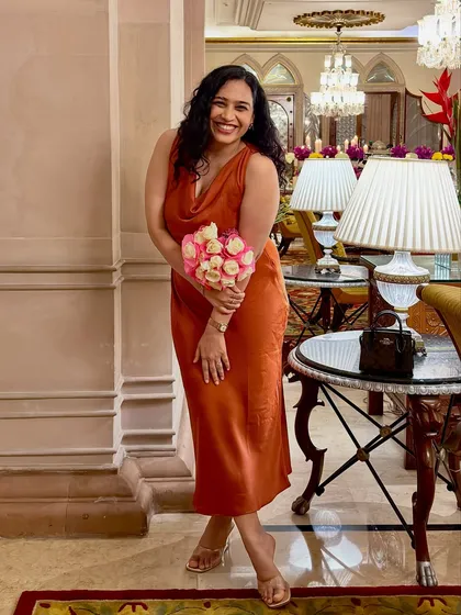 A beautiful photo of me with a bouquet of roses from our anniversary celebration. It's a romantic and happy image that shares a personal, celebratory moment.