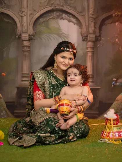 A beautiful moment between mother and child during a Janmashtami photoshoot. The mother holds her little Krishna, who is holding a small matki, creating a tender and culturally rich portrait.
