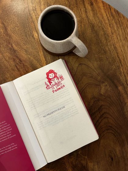 A quiet moment with a book and a black coffee. This book, 'No Presents Please', is by a regular at our reading socials.