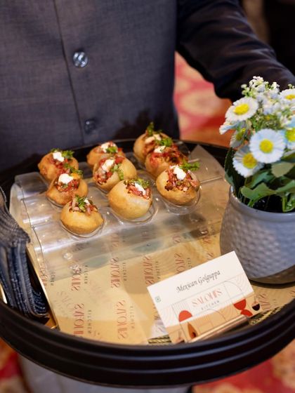 A server presenting my Mexican Gol Gappas. This is a fun fusion appetizer where the traditional puri is filled with a zesty Mexican-inspired mix instead of the usual spiced water.