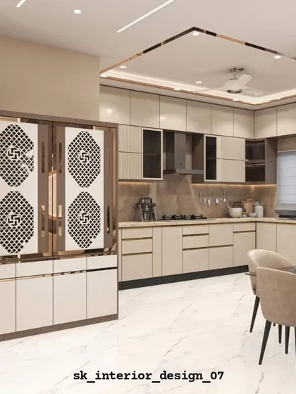 An open-plan kitchen and dining area. The kitchen features beige cabinets and is separated from the dining space by a custom jali partition that doubles as a pooja unit.