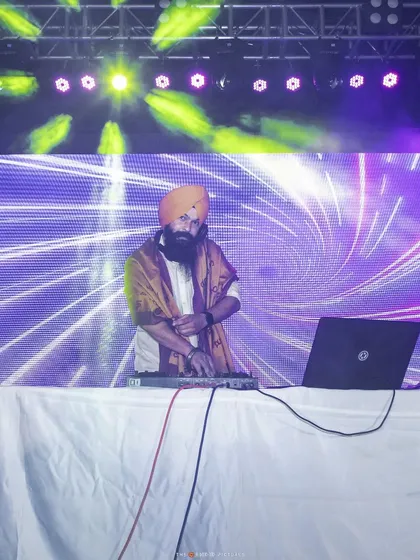 At my console with a large LED backdrop. I work with event planners to ensure my setup integrates perfectly with the stage design for a professional look.