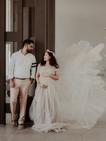 An elegant maternity portrait. The flowing dress creates a sense of movement and grace, making for a truly beautiful and artistic photograph.