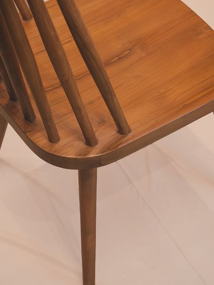 A detail of the 'Alto' chair, showing how the spindles are joined to the sculpted teak seat. This is a mark of true craftsmanship.