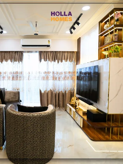 A view of the seating area in the Parisian living room. The combination of a plush sofa and a patterned barrel chair provides comfortable and stylish seating, perfect for relaxing or entertaining guests.