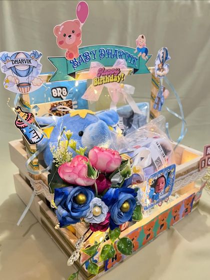 A three quarter view of the baby milestone hamper, showing how the flowers, personalized signs, and gifts come together to create a visually rich and heartfelt present.