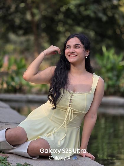 A fun and relaxed portrait by the water. Her bright smile and the summery yellow dress give this shot a cheerful and carefree vibe.