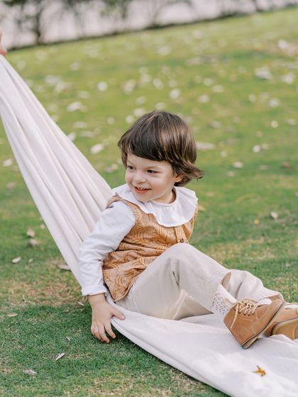 A little boy enjoying a swing made from a blanket. Simple games often lead to the biggest smiles.