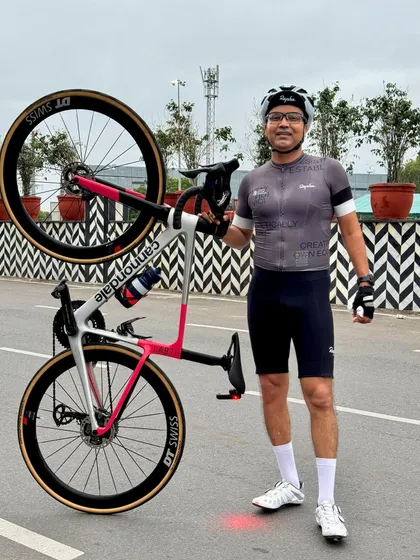 A member proudly lifting his Cannondale bike, a common celebration after a great ride.