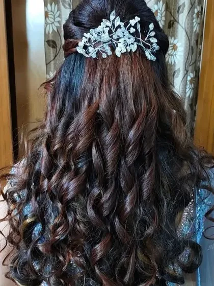 The back view of a half-up, half-down curly hairstyle, showing the volume and texture.
