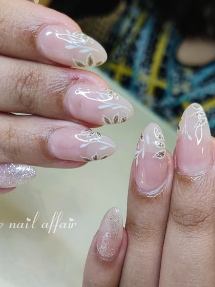 An elegant and delicate design with a sheer pink base, hand-painted white and gold leaf patterns, and a touch of glitter.