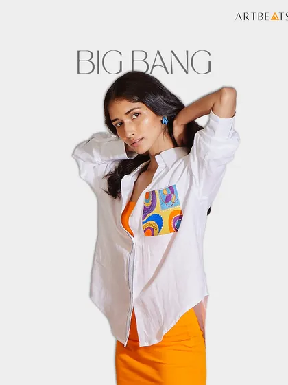 This is my Big Bang oversized shirt, made from airy, UV-protective hemp. It’s a playful take on a classic white shirt, with a pocket that serves as a mini canvas for my vibrant, hand-drawn art. It’s a versatile piece for anyone who loves to add a pop of color to their day.