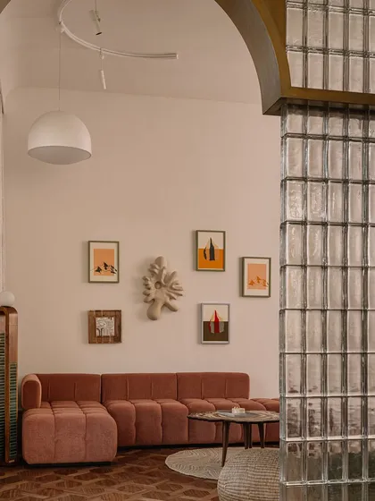 This image captures a collection of our unique seating and table designs. From a plush, channel-tufted sofa to a sculptural lounge chair made of upholstered stone, each piece is designed to be a work of art.