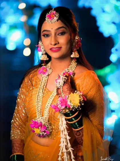 A closer look at the bride's radiant smile, framed by my handcrafted floral maang tika, necklace, and jhumkas. I designed this set to be bright and joyful, perfect for a lively Haldi celebration.