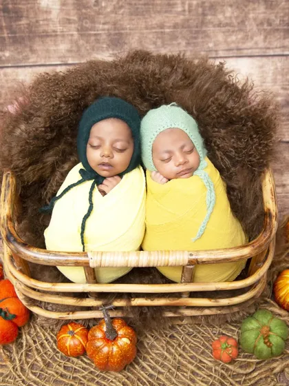 I specialize in newborn twin photography, and this autumn-themed setup is a client favorite. Here, two sleeping twins are swaddled snugly in a wicker basket, surrounded by colorful pumpkins and fall foliage.