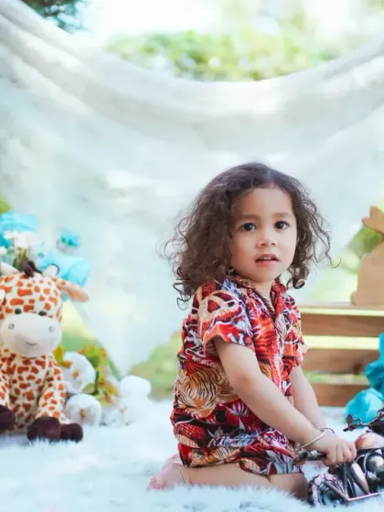 A candid portrait of a little boy playing with a toy motorcycle during his outdoor session.