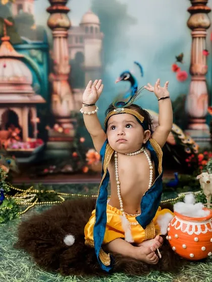 Arms up in a joyful pose! This is such a classic and adorable moment from a baby Krishna photoshoot.