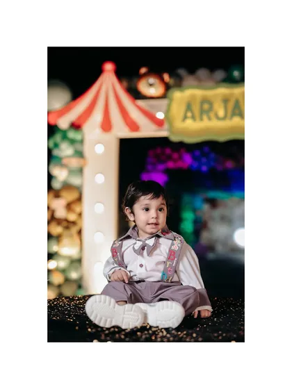 An artistic portrait of the birthday boy at his carnival party. The framing and lighting highlight him as the main event.