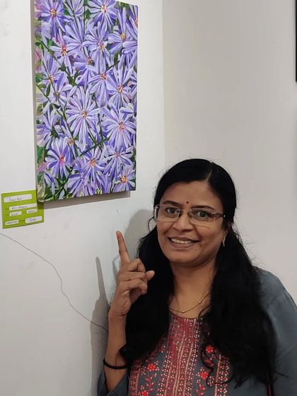 A smiling photo of me next to my painting at the exhibition.