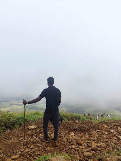 A lone trekker looking out at the misty mountains of Kudremukha. It's a place for adventure but also for quiet reflection.