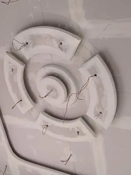 A circular POP design with curved segments, with wires indicating placement for numerous small spotlights to create a sparkling effect.