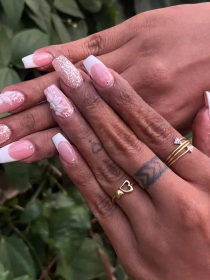 A timeless bridal look combining a classic French manicure with delicate 3D floral sculptures and glitter accents. This set of acrylic extensions shows how we can blend classic elegance with personalized art for your special day.