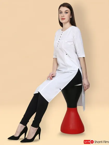 A modern, chic pose highlights this white kurti against a warm, neutral background. We use creative posing and props to add a dynamic feel to standard catalogue shoots.
