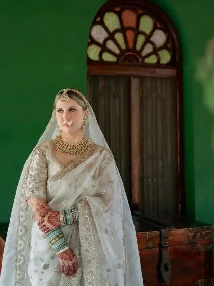 The bride's henna-stained hands are gracefully clasped, showing the deep, even color of the design.