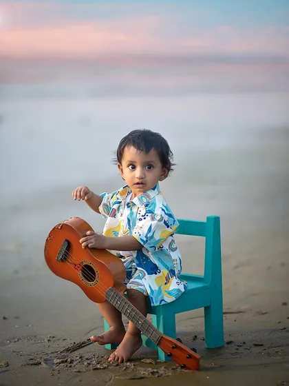 Exploring the textures of the guitar and the sand. Outdoor shoots are a wonderful sensory experience for little ones, leading to authentic, curious expressions.