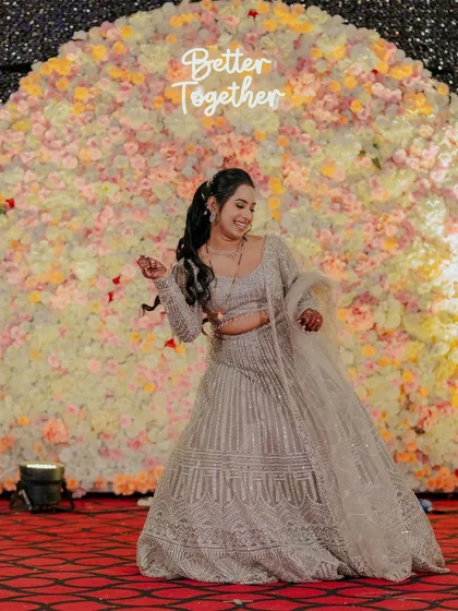 The bride posing against a beautiful floral backdrop, looking joyful and carefree.
